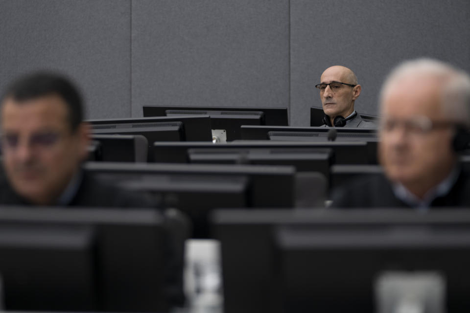 Salih Mustafa, a former Kosovo rebel, waits in the Kosovo Specialist Chambers court for the judges to read the verdict in The Hague, Netherlands, Friday, Dec. 16, 2022. Mustafa is charged with the war crimes of arbitrary detention, cruel treatment, the torture of at least six people and the murder of one person at a detention compound in Zllash, Kosovo, in April 1999. Salih Mustafa pleaded not guilty to all charges. (AP Photo/Peter Dejong, Pool)