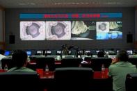 Chinese technicians at the Jiuquan Space Centre monitor the Shenzhou-9 spacecraft as it prepares to link with the Tiangong-1 module. A Chinese spacecraft has successfully completed the country's first manual docking in orbit, a milestone in an ambitious programme to build a space station by the end of the decade