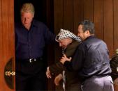 FILE PHOTO: Israeli Prime Minister Ehud Barak jokingly pushes Palestinian President Yasser Arafat into the Laurel cabin on the grounds of Camp David