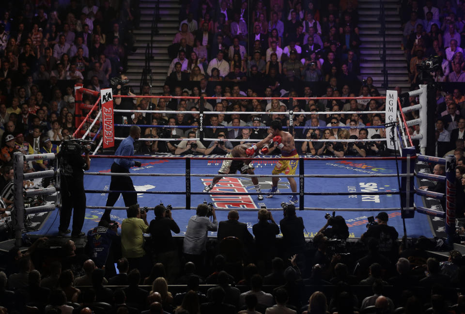 Manny Pacquiao, from the Philippines, right, hits Floyd Mayweather Jr., during their welterweight title fight on Saturday, May 2, 2015 in Las Vegas. (AP Photo/Eric Jamison)