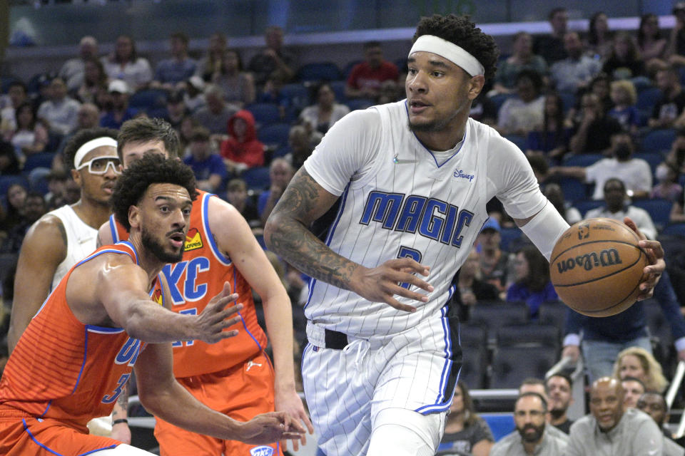 Orlando Magic forward Chuma Okeke, right, drives to the basket past Oklahoma City Thunder center Olivier Sarr, left, during the first half of an NBA basketball game, Sunday, March 20, 2022, in Orlando, Fla. (AP Photo/Phelan M. Ebenhack)