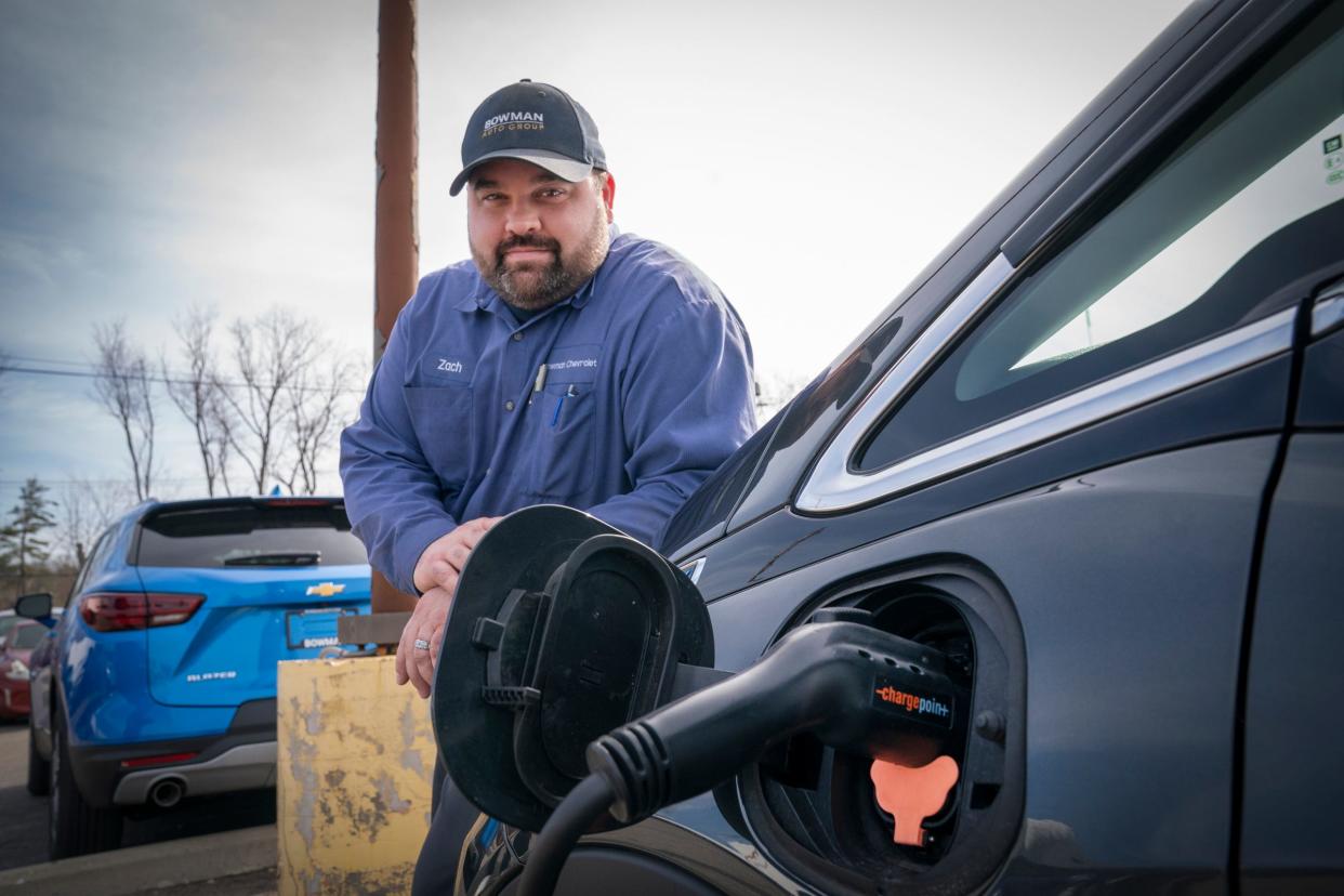 Bowman Chevrolet technician, Zach Vanwert, 37, of Swartz Creek, poses for a photo with a used 2020 Chevrolet Bolt EV in the parking lot of his employer in Clarkston on Wednesday, April 10, 2024.