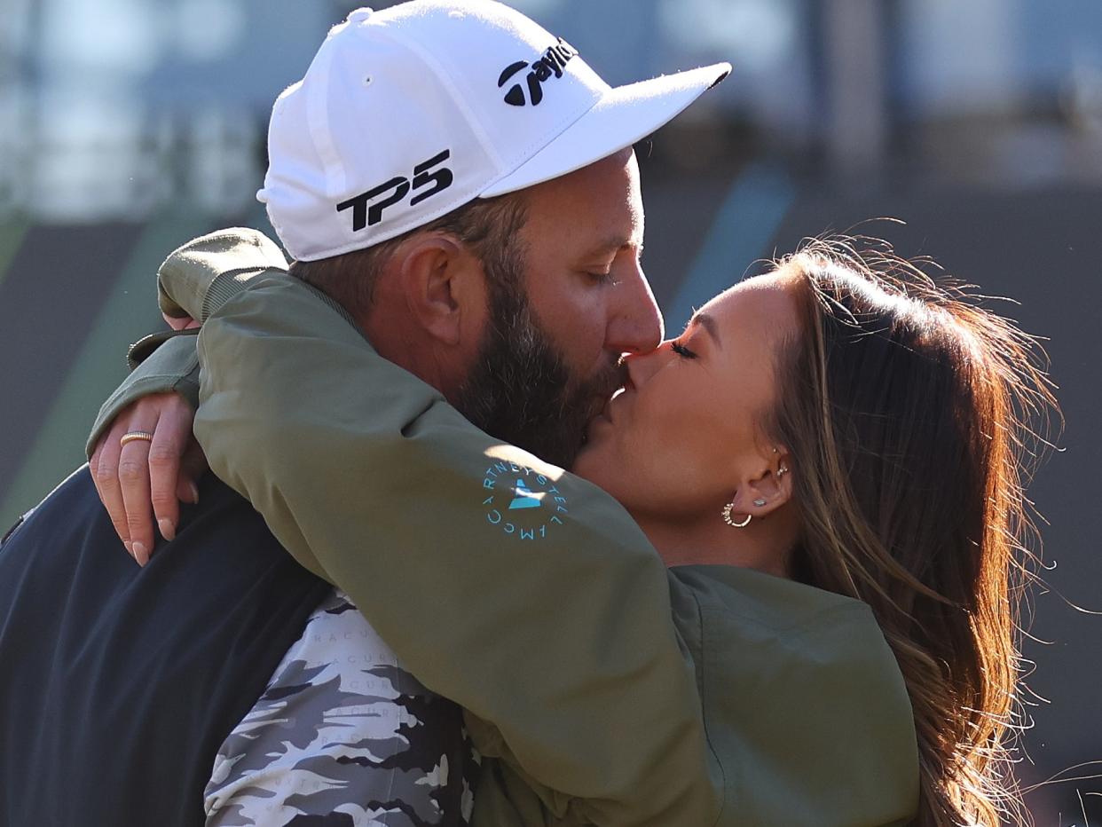 Paulina Gretzky gives husband, Dustin Johnson, a kiss while he plays golf. 