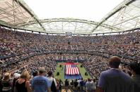 Overall view of the stadium as U.S. Marines hold a large U.S. flag during the opening ceremony for the women's singles final match between Roberta Vinci of Italy and compatriot Flavia Pennetta at the U.S. Open Championships tennis tournament in New York, September 12, 2015. REUTERS/Carlo Allegri