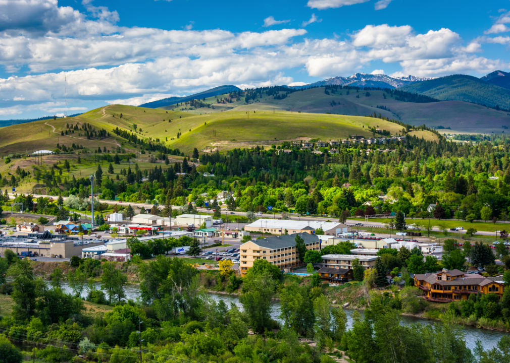 Town situated by the river with green mountain tops in the background.