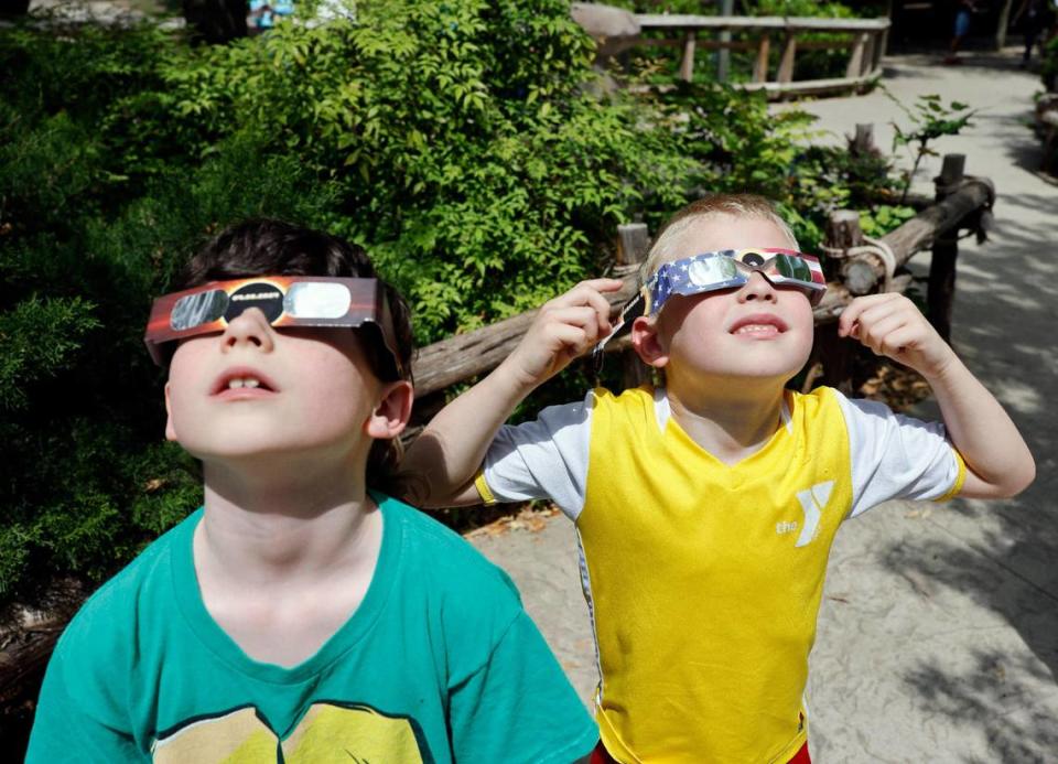 J.J. Massey, 8 and his brother James,6, look at the sun before the total solar eclipse at the Fort Worth Zoo in Fort Worth, Texas, Monday Apr 08, 2024.