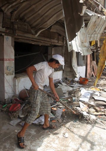 An Iraqi man clears the debris the day after twin car bombs in the Karrada area of Baghdad. July was the deadliest month in Iraq in almost two years, with 325 people killed in attacks, official figures released on Wednesday showed, and included the deadliest day here since December 2009