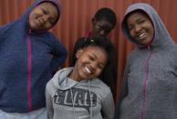 Lilitha Jiphethu, 11, poses for a photo with her friends outside her home in Orange Farm, South Africa, on Tuesday, April 28, 2020. She prefers singing to drawing and chooses to sing a church song in her first language, Xhosa, as her way of describing the future after the pandemic. She misses her choir but takes comfort in the song’s lyrics. (AP Photo/Denis Farrell)