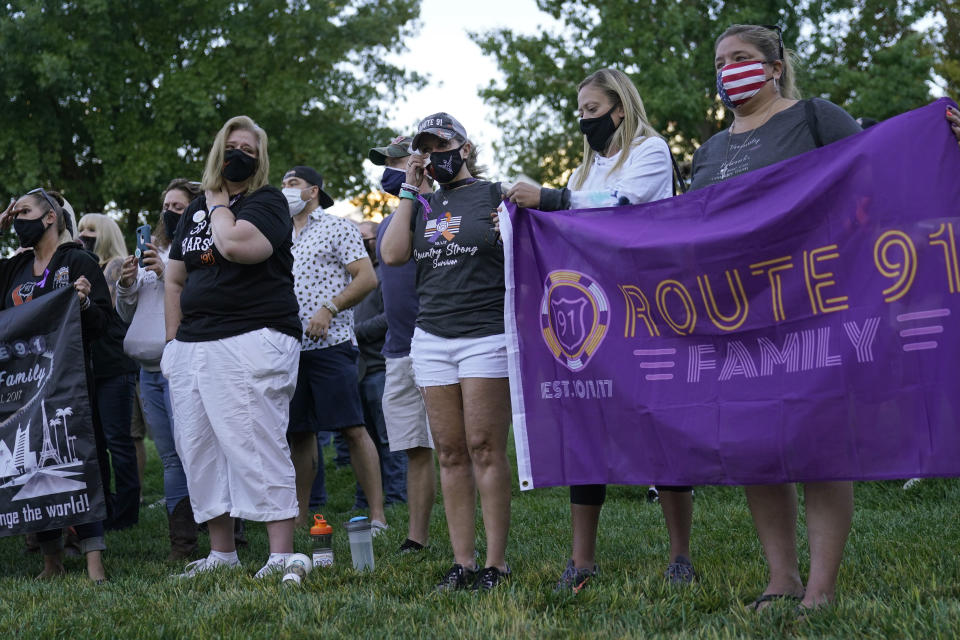 Kimberly Mower, center, of Denver, wipes tears from her eyes during a ceremony Thursday, Oct. 1, 2020, on the anniversary of the mass shooting three years earlier in Las Vegas. The ceremony was held for survivors and victim's families of the deadliest mass shooting in modern U.S. history. (AP Photo/John Locher)