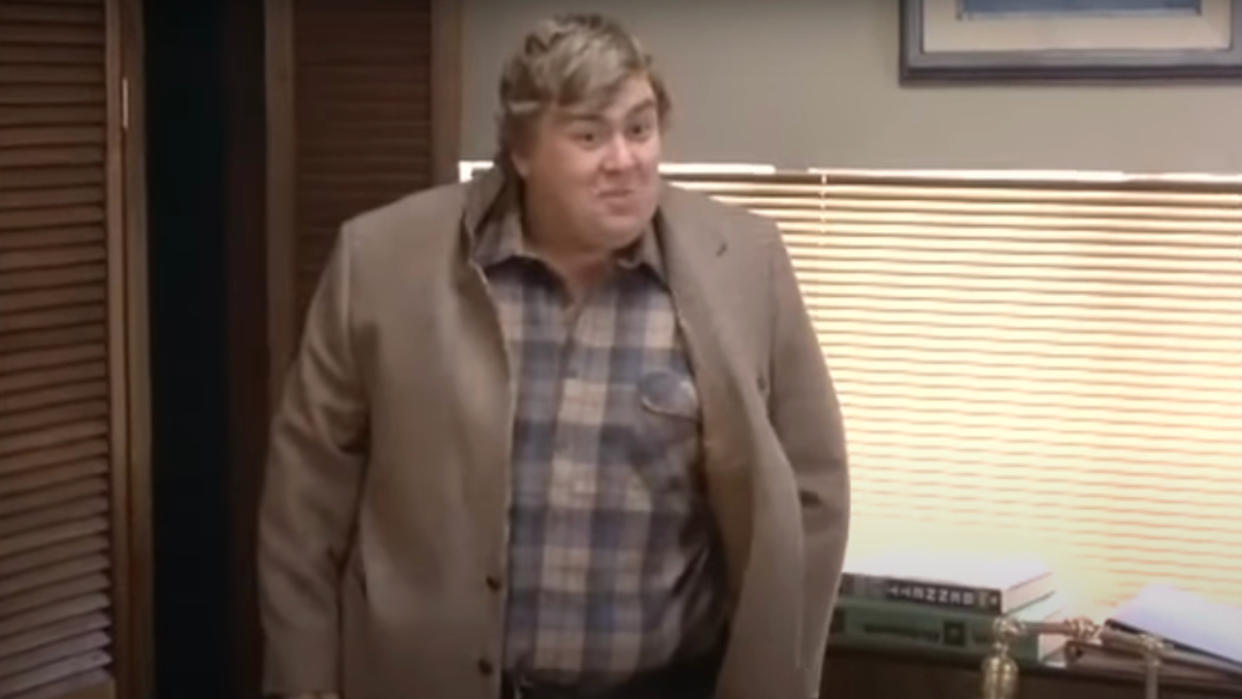  John Candy smiles while standing in an office in Splash. 