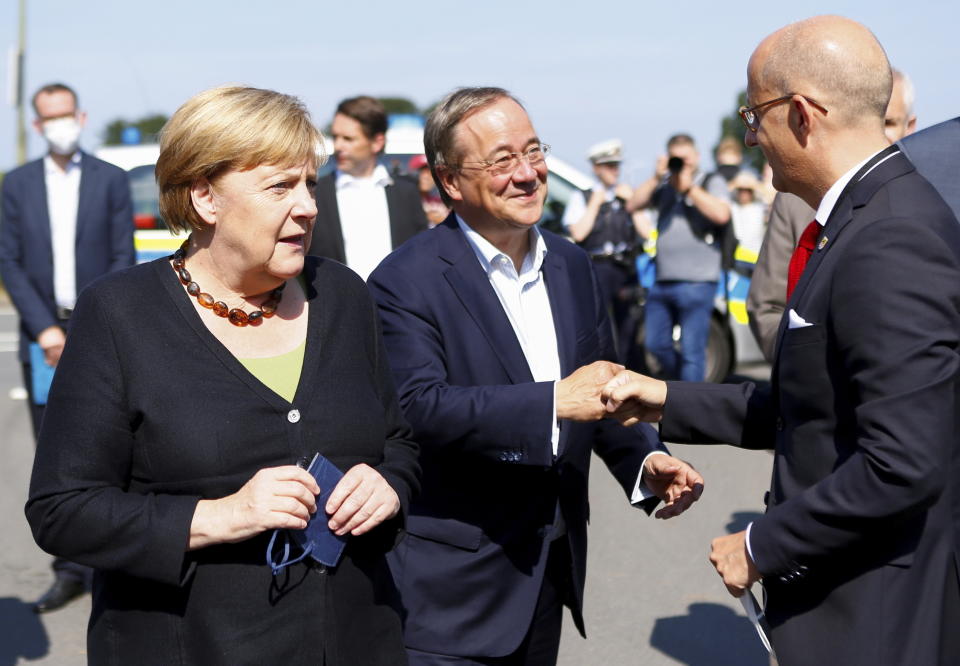 German Chancellor Angela Merkel and North Rhine-Westphalia's State Premier, chairman of the Christian Democratic Union party and candidate for Chancellery Armin Laschet, center, visit the fire station in Schalksmuehle, Germany, Sunday Sept. 5, 2021. (Thilo Schmuelgen/Pool via AP)