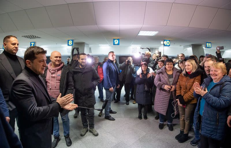 Ukraine's President Zelenskiy greets citizens who were exchanged during a prisoners of war swap at an airport outside Kiev