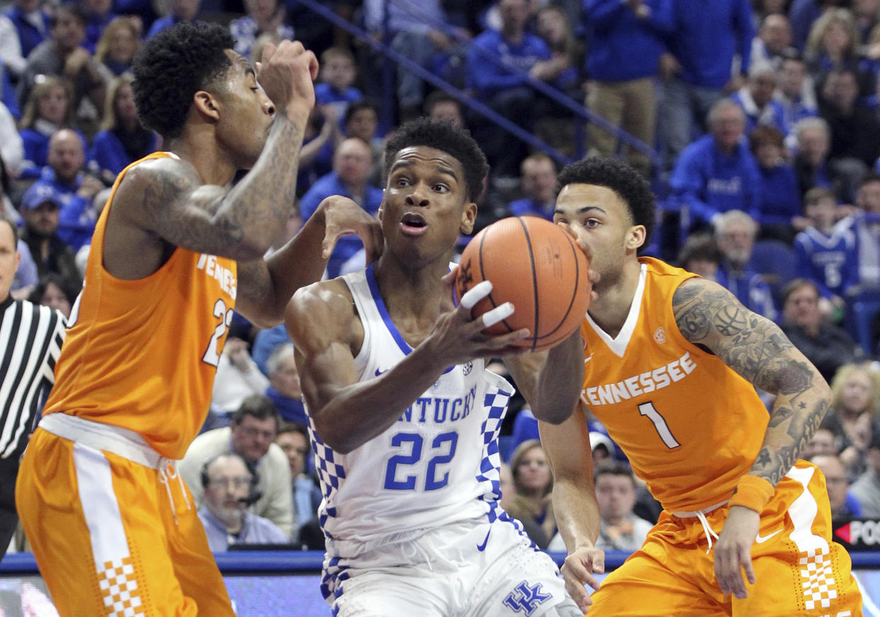 Kentucky’s Shai Gilgeous-Alexander, middle, drives between Tennessee’s Jordan Bowden, left, and Lamonte Turner (1) during the first half of an NCAA college basketball game, Tuesday, Feb. 6, 2018, in Lexington, Ky. (AP Photo/James Crisp)