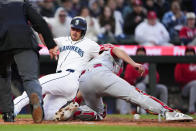 Seattle Mariners' Mitch Garver slides home to score on a double by Jonatan Clase, while Cincinnati Reds catcher Luke Maile drops the ball during the fourth inning of a baseball game Tuesday, April 16, 2024, in Seattle. (AP Photo/Lindsey Wasson)