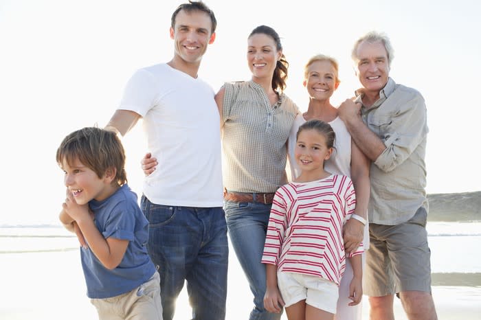 A family portrait of three generations at the beach.