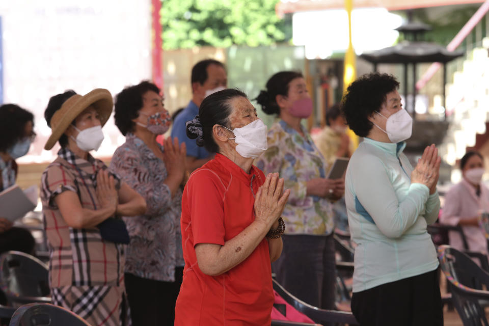 People wearing face masks to help protect against the spread of the new coronavirus pray during a service at the Chogyesa temple in South Korea, Monday, June 22, 2020. (AP Photo/Ahn Young-joon)