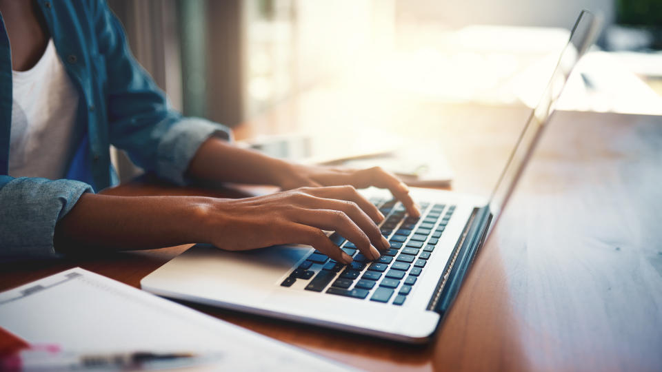 Closeup shot of an unrecognizable woman using a laptop while working from home.