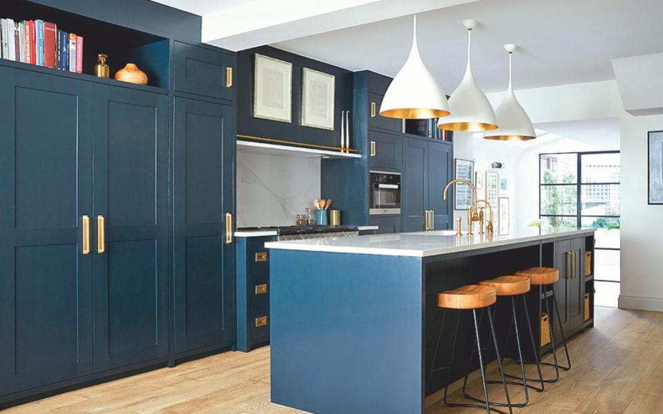 The kitchen cabinetry is painted in Black Blue by Farrow & Ball; the handles are from Armac Martin and the pendant lights are by Visual Comfort - Paul Massey