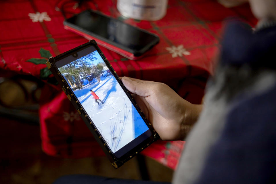 Image: Maria Pineda watches a video of her son, Cristian Pavon Pineda, 11-years-old, playing in the snow for the first time on Feb. 18, 2021, in Conroe, Texas (Gustavo Huerta / Houston Chronicle via AP)