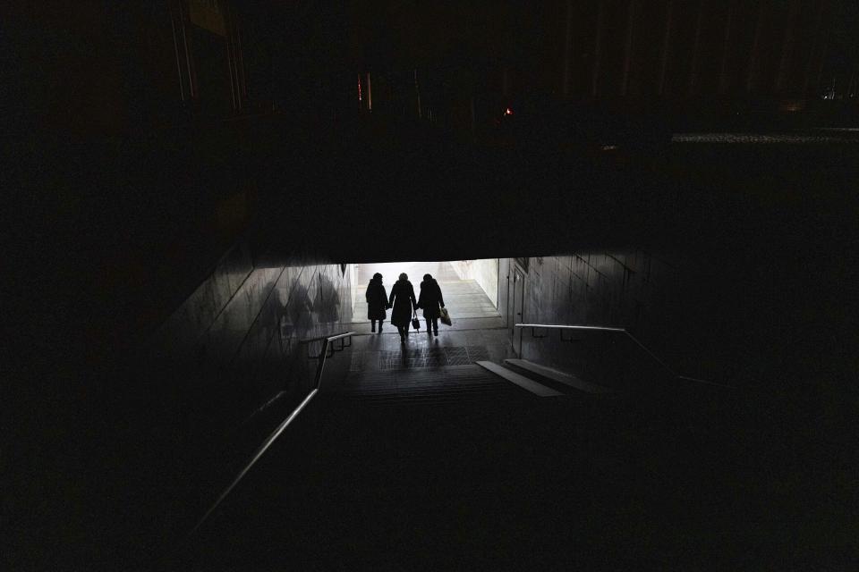 Varias mujeres caminan por un túnel para tomar el metro en el centro de la ciudad de Járkiv, Ucrania, el miércoles 21 de diciembre de 2022. (AP Foto/Evgeniy Maloletka)