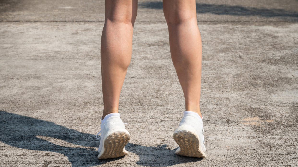  View of a woman's lower legs performing a calf raise 