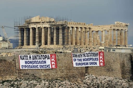 Banners reading: "down with the dictatorship of the monopolies european union" are seen in front on the Parthenon Temple at the ancient Acropolis hill on February 11. Police were deployed in force in Athens for a second day of protests after the Greek cabinet approved tough austerity cuts to get international rescue funds and avoid the "chaos" of a default