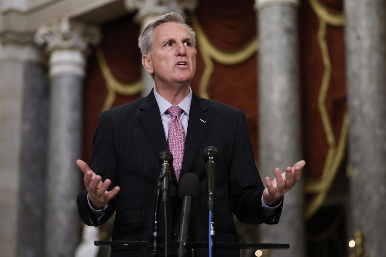 House Speaker Kevin McCarthy answers questions from reporters with the columns of Statuary Hall behind him.