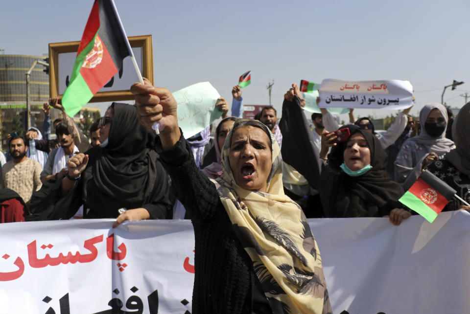 Afghan women shout slogans and wave Afghan national flags during an anti-Pakistan demonstration, near the Pakistan embassy in Kabul, Afghanistan, Tuesday, Sept. 7, 2021. Sign in Persian at right reads, "Pakistan Pakistan Get out from Afghanistan." (AP Photo/Wali Sabawoon)