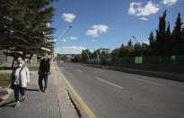 Elderly people wearing face masks for protection against the coronavirus, walk along the main Ataturk Boulevard in Ankara, Turkey, Sunday, May 24, 2020, during a four-day curfew declared by the government in an attempt to control the spread of coronavirus. Turkey's senior citizens were allowed to leave their homes for a third time as the country continues to ease some coronavirus restrictions. (AP Photo/Burhan Ozbilici)