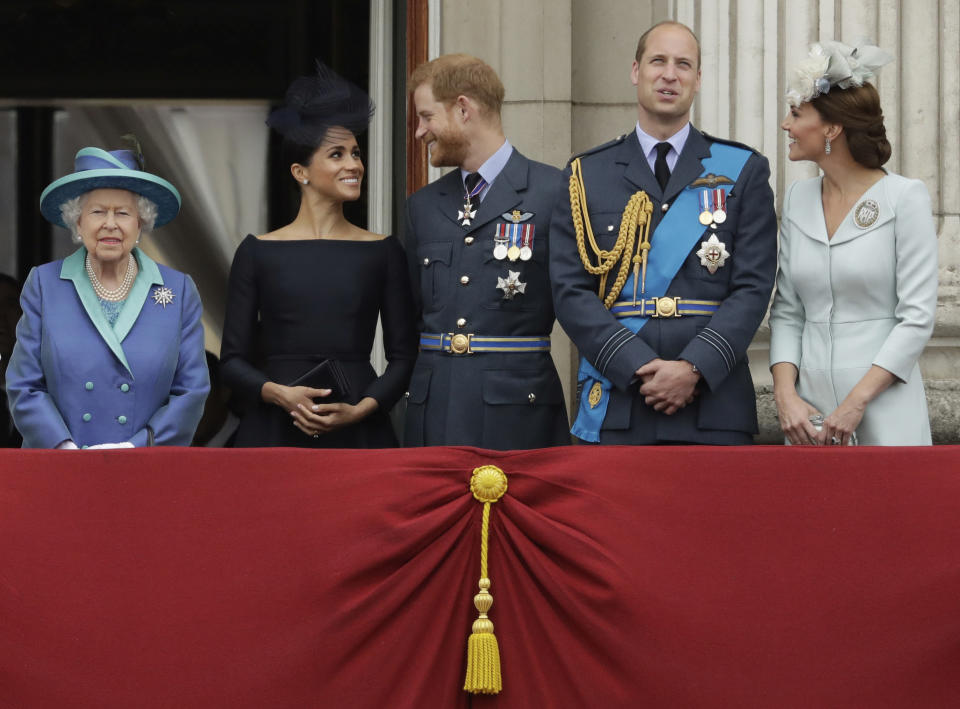 FILE - In this Tuesday, July 10, 2018 file photo Britain's Queen Elizabeth II, and from left, Meghan the Duchess of Sussex, Prince Harry, Prince William and Kate the Duchess of Cambridge watch a flypast of Royal Air Force aircraft pass over Buckingham Palace in London. Prince Harry has said he wants to have his father and brother back and that he wants “a family, not an institution,” during a TV interview ahead of the publication of his memoir. The interview with Britain’s ITV channel is due to be released this Sunday. (AP Photo/Matt Dunham, File)