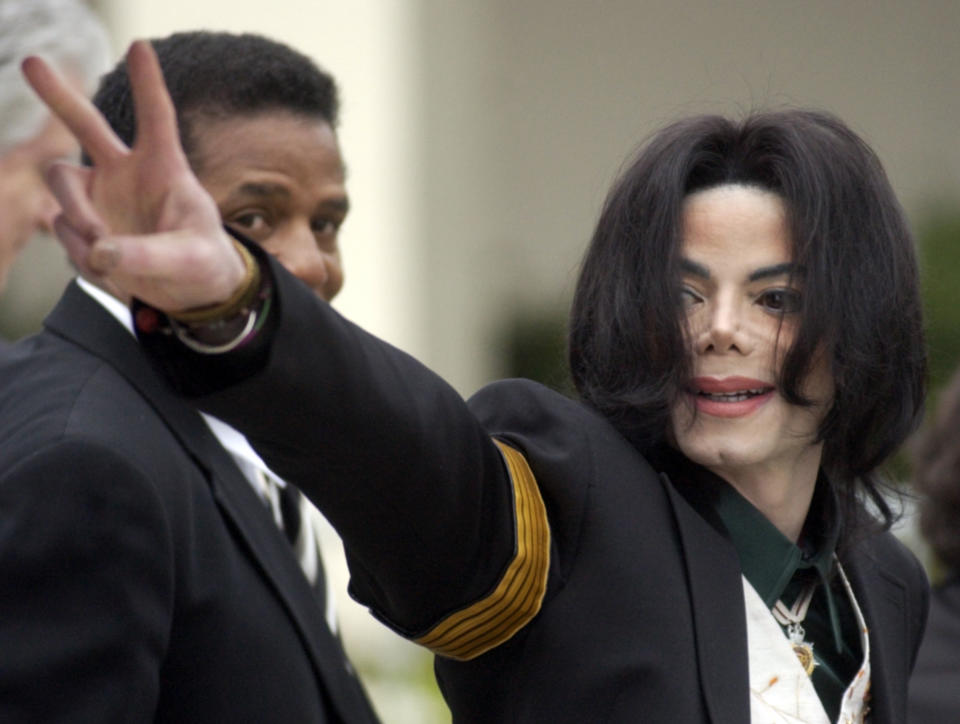 FILE - In this March 2, 2005, file photo, pop icon Michael Jackson waves to his supporters as he arrives for his child molestation trial at the Santa Barbara County Superior Court in Santa Maria, Calif. A California appeals court is strongly inclined to give new life to lawsuits filed by two men who accuse Michael Jackson of molesting them when they were boys. In a tentative ruling Monday, the 2nd District Court of Appeal said lawsuits from James Safechuck and Wade Robson should be reconsidered by the trial court that dismissed them in 2017. The decision is based on a new California law that gives sex abuse victims far longer to sue. (AP Photo/Michael A. Mariant, File)