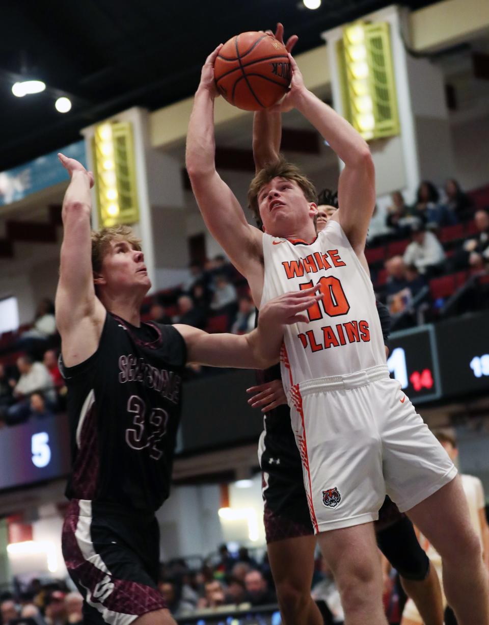 White Plains Luke Brooks (10) drives to the basket in front of Scarsdale's Oscar Langford (32) during the Slam Dunk Showcase at the Westchester County Center in White Plains Jan. 6, 2024.