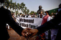 Opposition lawmakers hold a protest near a Gandhi statue demanding repeal of three controversial agriculture laws on the opening day of the winter session of Parliament in New Delhi, India, Monday, Nov.29, 2021. India’s parliament on Monday repealed a set of controversial agriculture laws that inflamed tens of thousands of farmers, whose year-long protest has posed one of the biggest challenges to Prime Minister Narendra Modi’s administration. (AP Photo/Manish Swarup)