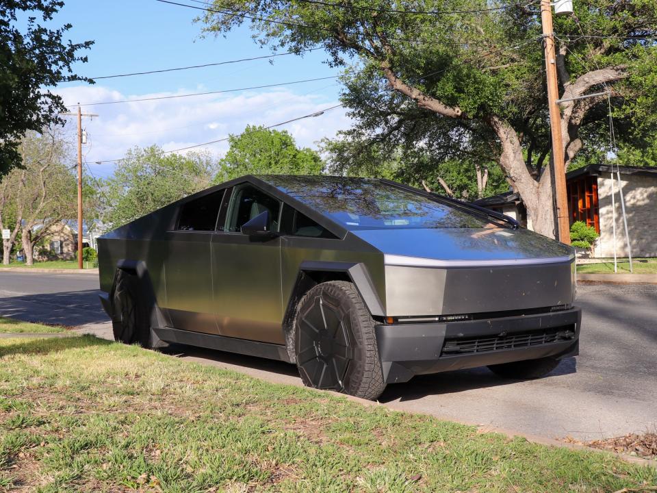 Tesla Cybertruck parallel parked on a curb in a residential neighborhood