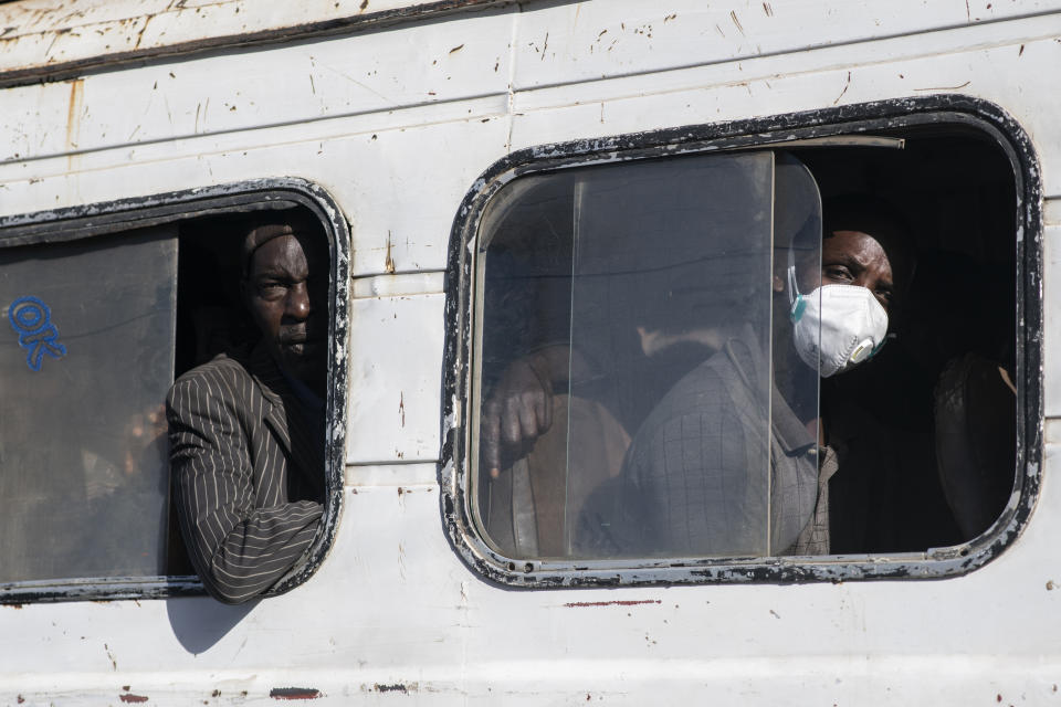 Travelers, some wearing a protective mask, take a bus from the Colobane Bus Station in Dakar, Senegal, Tuesday March 24, 2020. The transport Ministry has announced a limit to the number of passengers in the bus to prevent the risk of contamination by the Coronavirus. The highly contagious COVID-19 coronavirus can cause mild symptoms, but for some it can cause severe illness including pneumonia that may force admission to hospital. (AP Photo/Sylvain Cherkaoui)