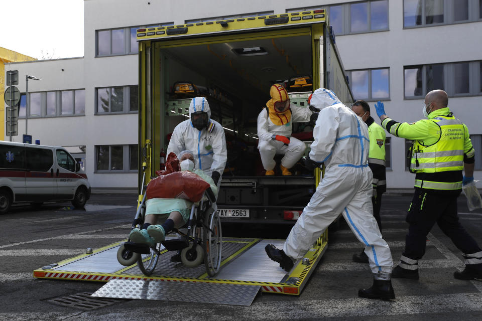 FILE - Health care workers transport a COVID-19 patient, in Ceska Lipa, Czech Republic, Thursday, March 18, 2021.The number of COVID-19 patients in the Czech Republic has begun to grow amid a record surge of infections driven by the highly contagious omicron coronavirus variant. According to the figures released by Health Ministry on Tuesday Jan. 25, 2022. The number of hospitalized jumped to 1,695 on Monday and was on the rise for the second straight day, up from 1,537 the previous day. (AP Photo/Petr David Josek, File)