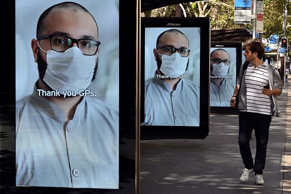 A man walks past bus stop advertising boards displaying thank you messages to health workers in response to the COVID-19 coronavirus outbreak in Sydney.