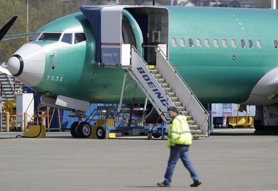FILE - In this April 26, 2019, file photo a worker walks past a Boeing 737 MAX 8 airplane being built for Oman Air at Boeing's assembly facility in Renton, Wash. Boeing Co. reports financial earns on Wednesday, Oct. 23. (AP Photo/Ted S. Warren, File)