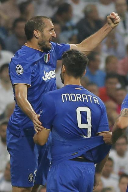 Juventus players celebrate after Alvaro Morata, right, scored 1-1 during the Champions League second leg semifinal soccer match between Real Madrid and Juventus, at the Santiago Bernabeu stadium in Madrid, Wednesday, May 13, 2015. The match ended in a 1-1 draw, Juventus won on aggregate and will play Barcelona in the Champions League final on June 6, 2015 in Berlin. (AP Photo/Daniel Ochoa de Olza)