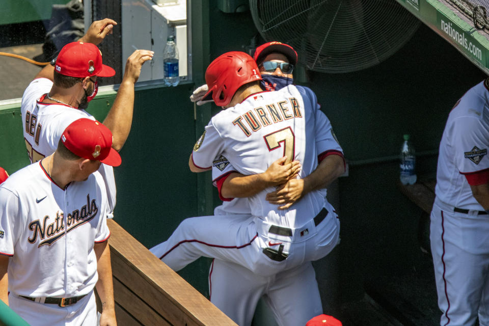 Washington Nationals' Trea Turner jumps into the arms of a teammate after his solo home run during the third inning of a baseball game against the New York Yankees at Nationals Park, Sunday, July 26, 2020, in Washington. (AP Photo/Alex Brandon)