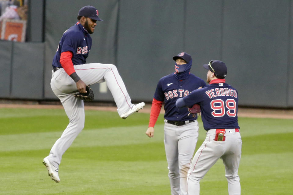 El dominicano Franchy Cordero salta para festejar con sus compañeros de los Medias Rojas de Boston, el puertorriqueño Kiké Hernández (centro) y el mexicano Alex Verdugo, luego de imponerse a los Mellizos de Minnesota en una doble cartelera, el miércoles 14 de abril de 2021 (AP Foto/Andy Clayton-King)