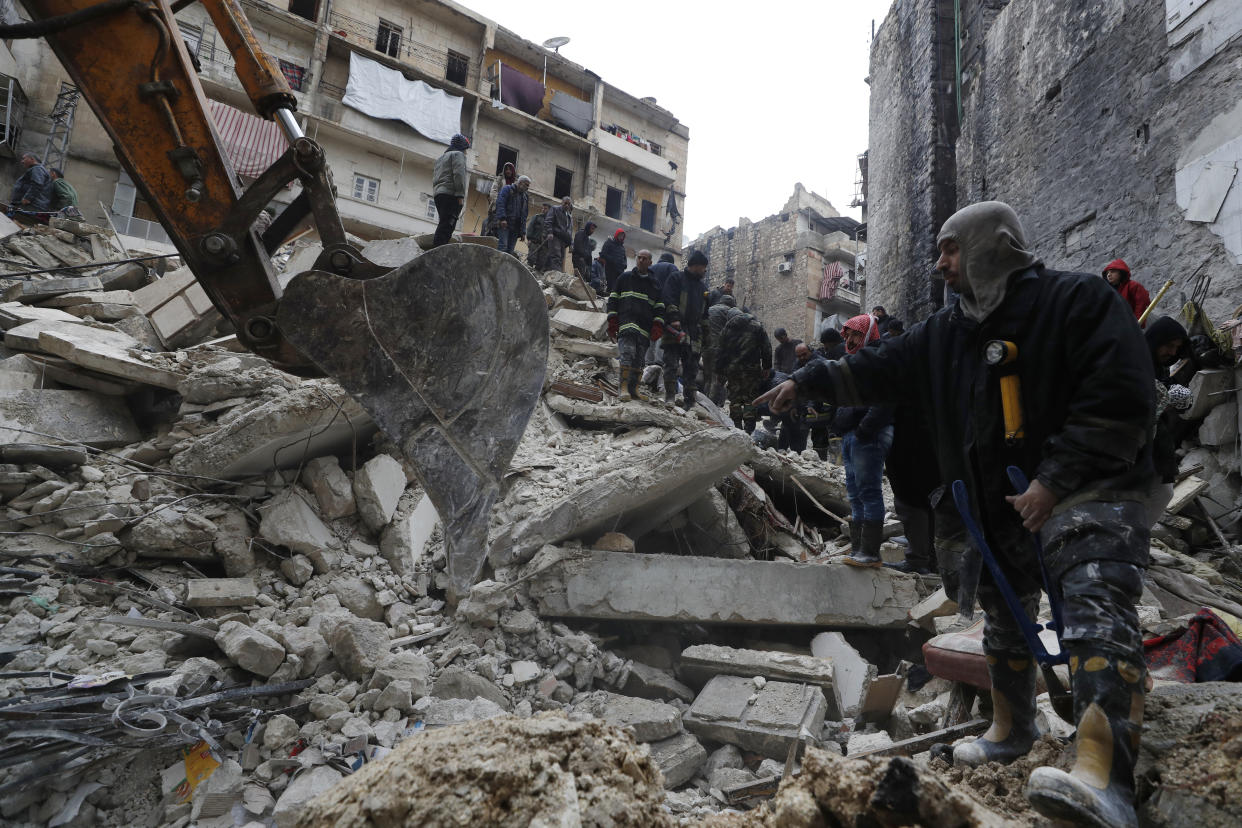 Syrian Civil Defense workers and security forces search through the wreckage of collapsed buildings, in Aleppo, Syria, Monday, Feb. 6, 2023. A powerful earthquake rocked wide swaths of Turkey and neighboring Syria on Monday, toppling hundreds of buildings and killing and injuring thousands of people. (AP Photo/Omar Sanadiki)