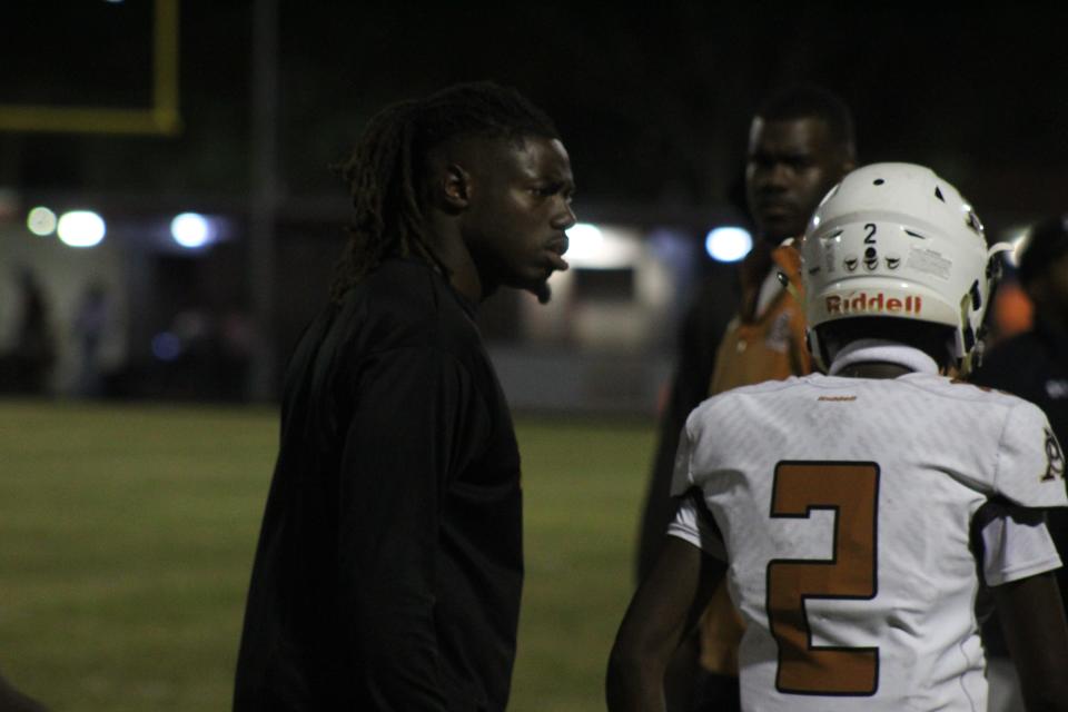 Atlantic Coast head coach Stephen Durham talks to a player during AC's 29-22 loss versus Raines.