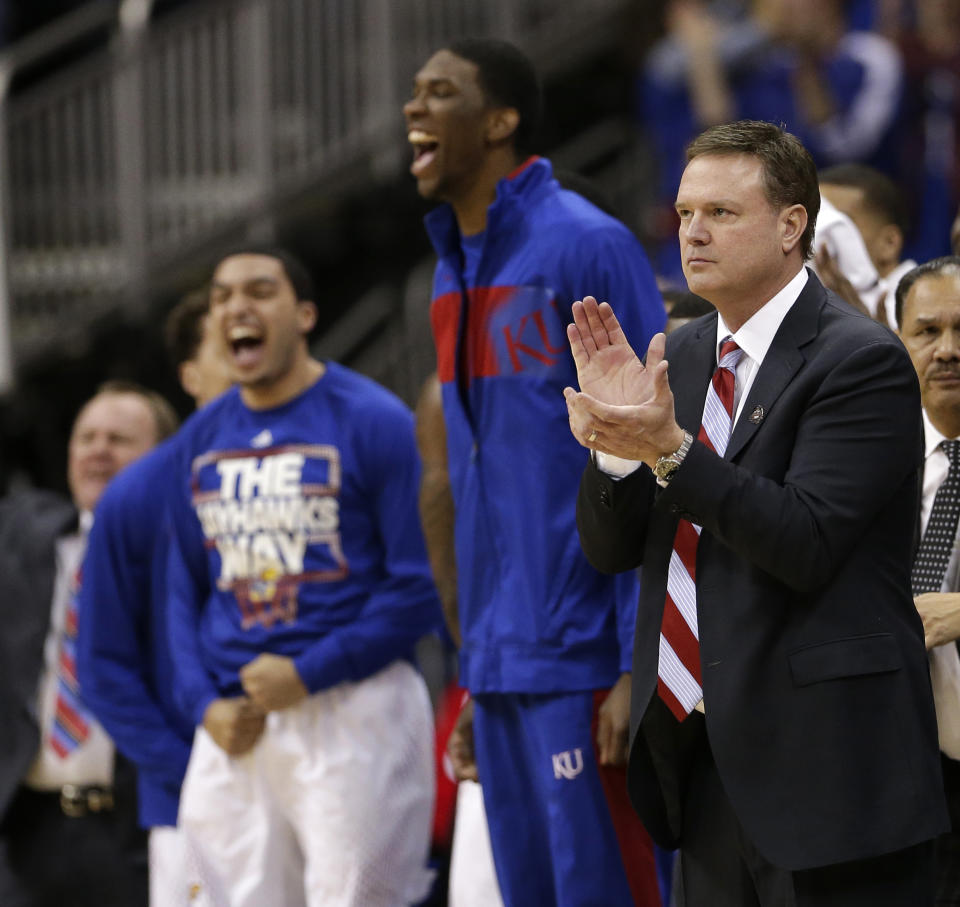 Kansas coach Bill Self, right, and the Kansas bench celebrate a basket during the first half of an NCAA college basketball game against Iowa State in the Big 12 men's tournament on Friday, March 14, 2014, in Kansas City, Mo. (AP Photo/Charlie Riedel)