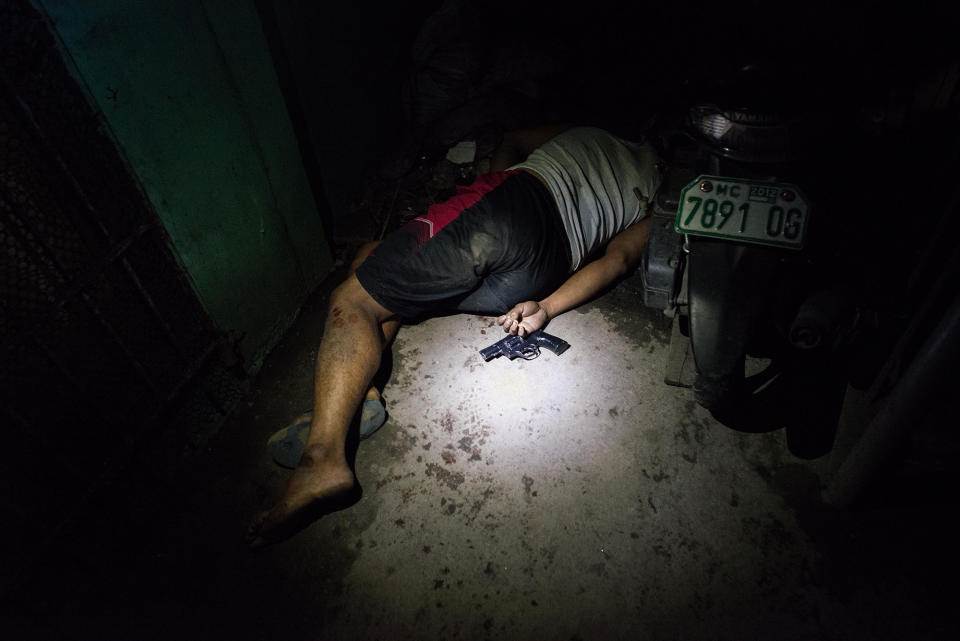 <p>A drug suspect lies dead in a hallway during an alleged shootout with police on August 18, 2016 in Manila, Philippines. (Dondi Tawatao/Getty Images) </p>