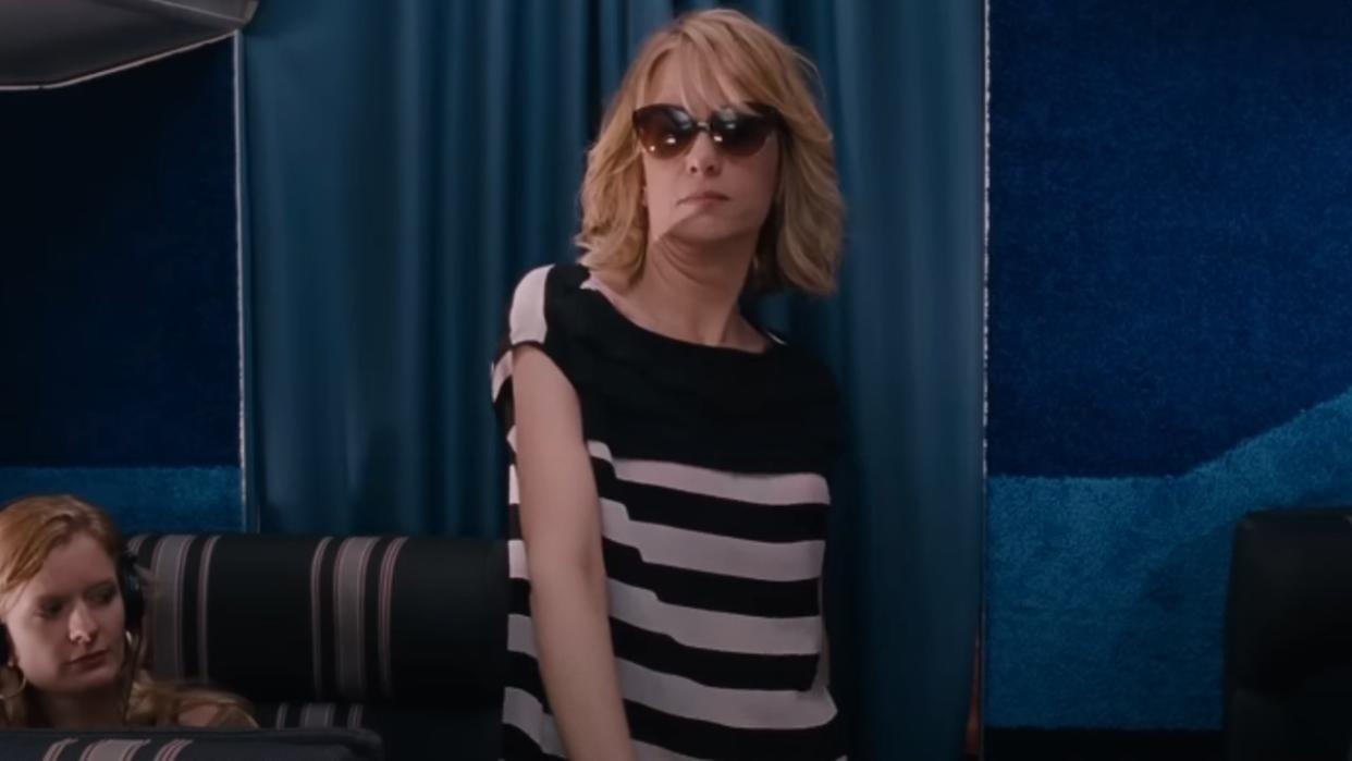  A screenshot of Kristen Wiig walking into first class with sunglasses on in Bridesmaids. 