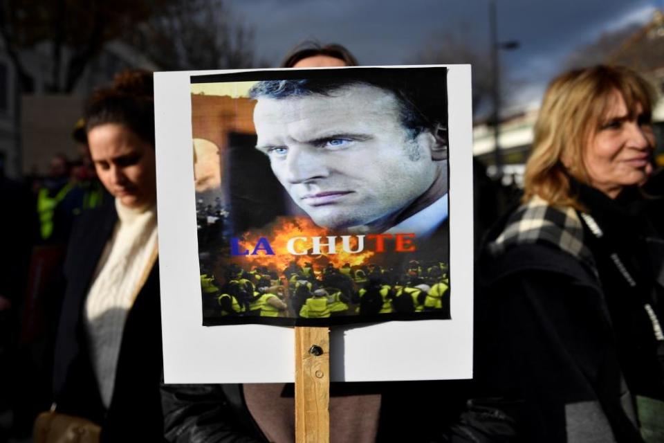 A woman holds a placard of Macron captioned ‘The Fall’ during pensions protests in Marseille.