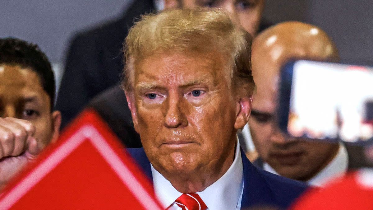 A picture of former US President Donald Trump standing at a campaign rally with sweat and an orange color on his face was shared online in January 2024. 