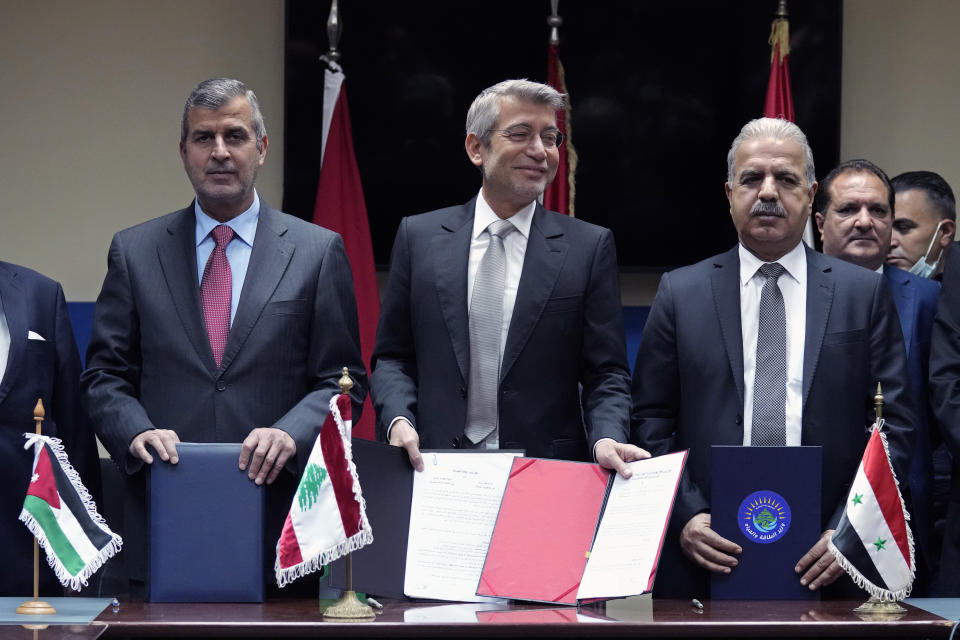 Lebanon's Energy Minister Walid Fayyad, center, Jordanian Energy Minister Saleh Kharabsheh, left, and Syria's Electricity Minister Ghassan al-Zamil, pose for a photograph after they sign deals to bring electricity from Jordan through Syria to Lebanon, at the Ministry of Energy and Water in Beirut, Lebanon, Wednesday, Jan. 26, 2022. Lebanon's electricity company offers only a couple of hours of power a day, and residents have heavily relied on costly and polluting private generators since the end of the civil war in 1990. (AP Photo/Bilal Hussein)