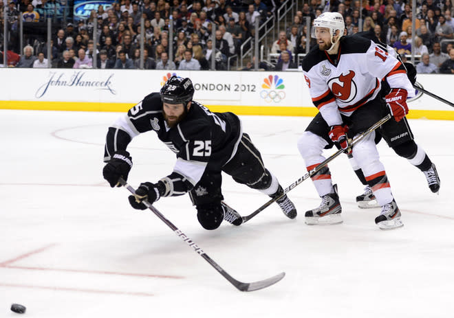 LOS ANGELES, CA - JUNE 04: Dustin Penner #25 of the Los Angeles Kings dives to play the puck as Travis Zajac #19 of the New Jersey Devils looks on during Game Three of the 2012 Stanley Cup Final at Staples Center on June 4, 2012 in Los Angeles, California. (Photo by Harry How/Getty Images)